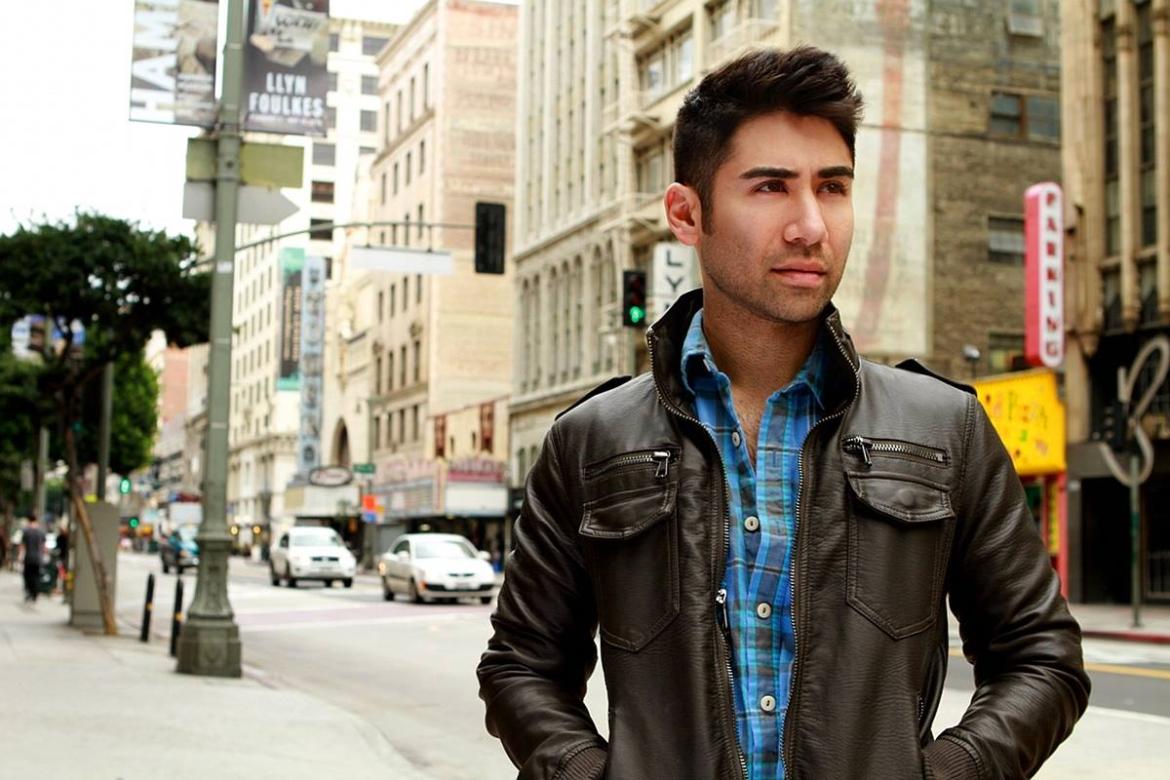 Photograph of UCLA alum Matthew Palazzolo wearing a jean jacket and standing in the streets of downtown Los Angeles.