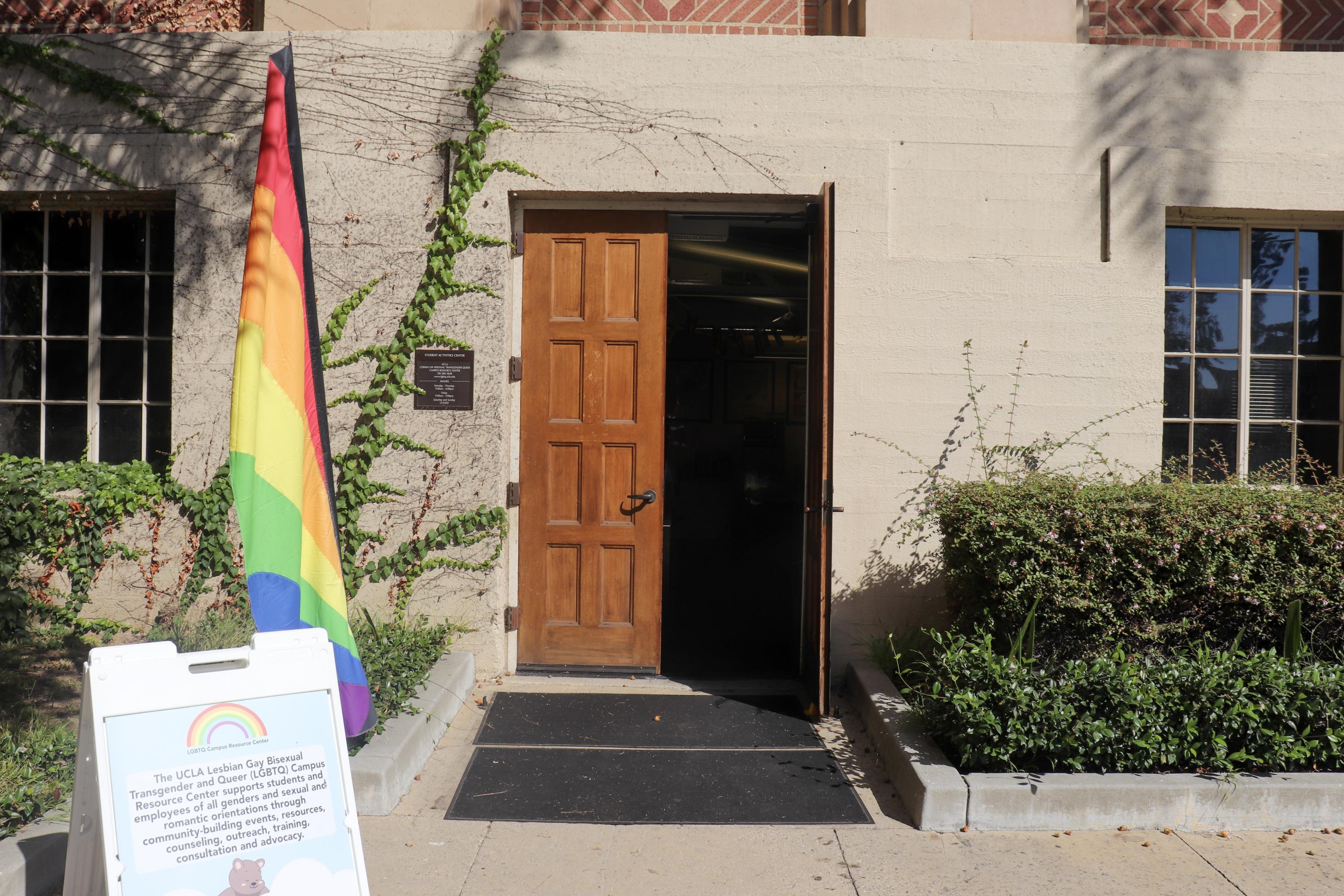 A picture of the front of center with the door open and the pride flag being on the left side of it 