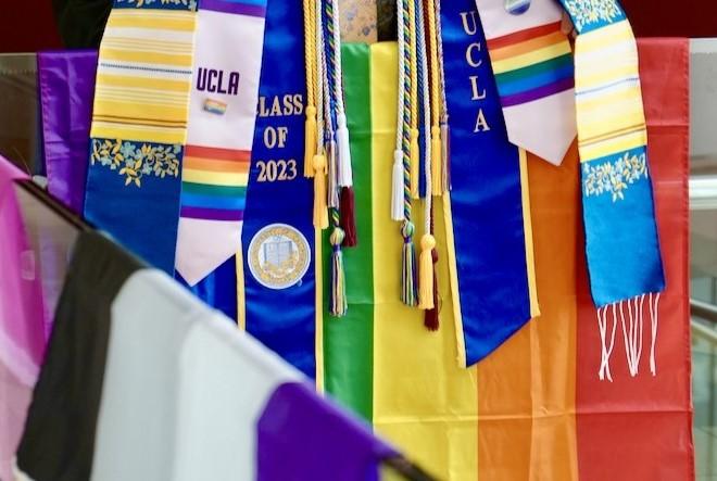 A collection of UCLA sashes with the rainbow pride flag.