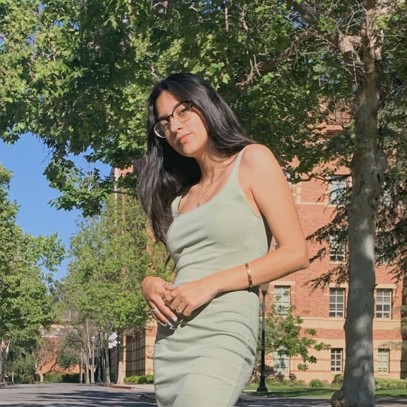 Photo of Samantha Gallegos in a green dress with her hands in front of her.